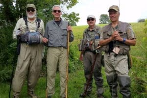 A group of men standing next to each other in a field.
