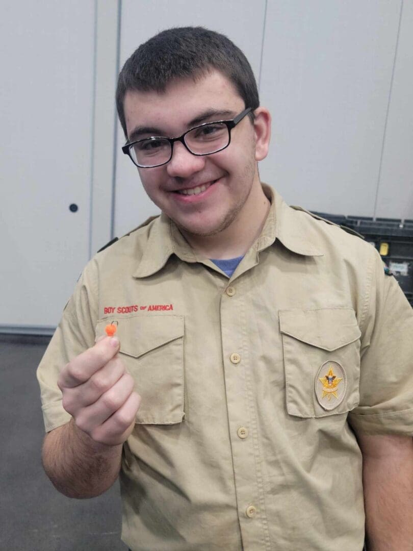 A boy in glasses and a beige uniform with a 