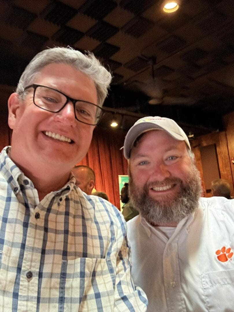 Two smiling men at a social event.